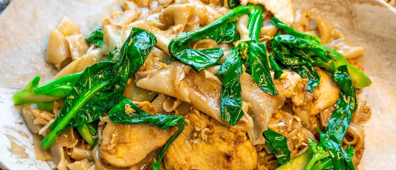 Wide rice noodles with leafy greens and tofu